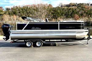 Sun Tracker Party Barge 22 RF DLX 2026 Sun Tracker Party Barge 22 RF DLX pontoon boat on trailer, scenic background.