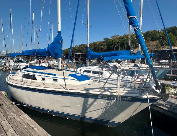 O'Day O'day 28 1983 O'Day 28 sailboat docked at marina with blue sails.