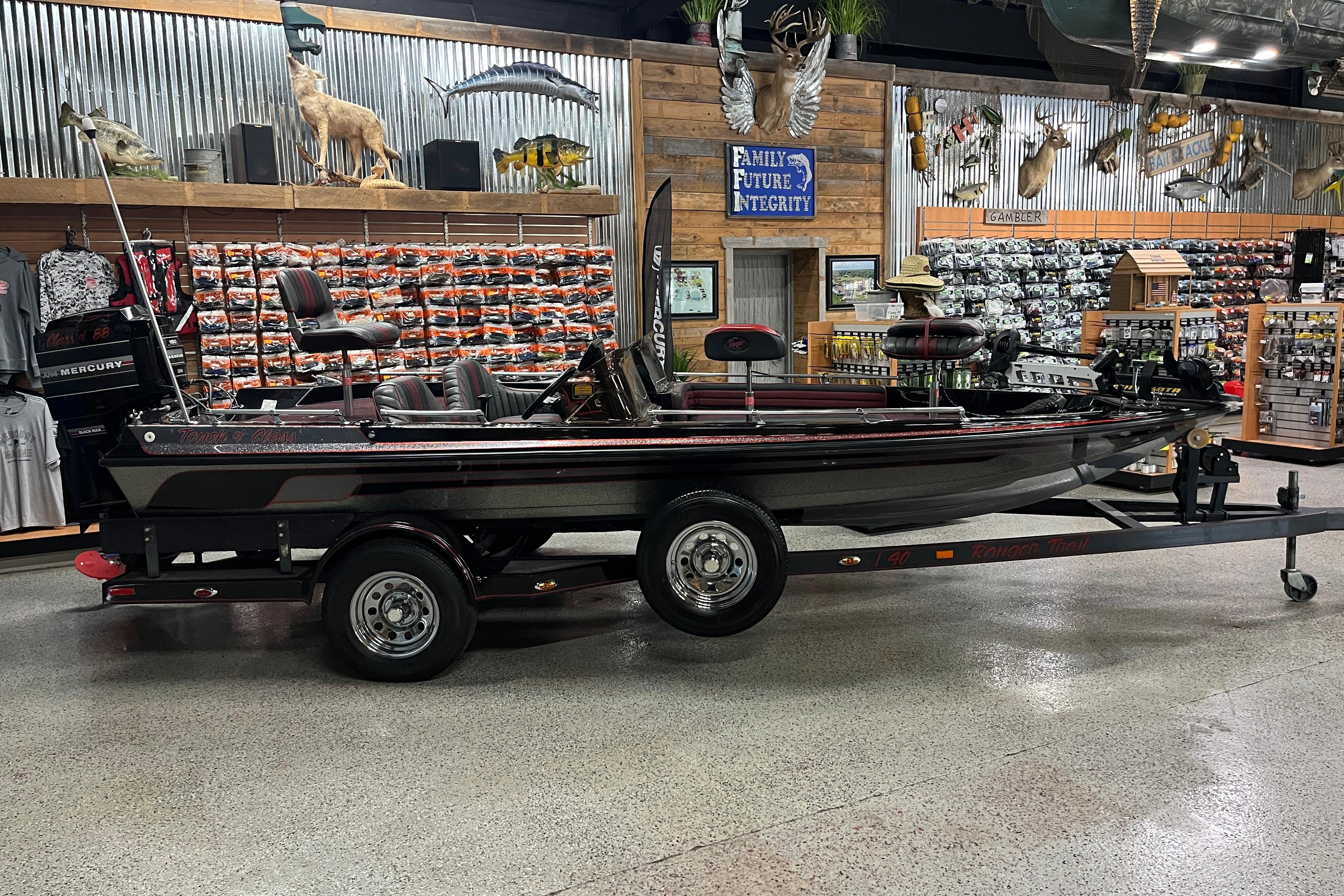 Ranger 361V 1988 Ranger 361V boat on trailer in a fishing gear store display.