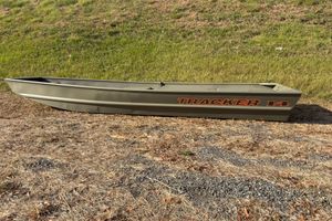 Tracker Grizzly 14 Jon 2026 Tracker Grizzly 14 Jon boat on grassy terrain, side view.