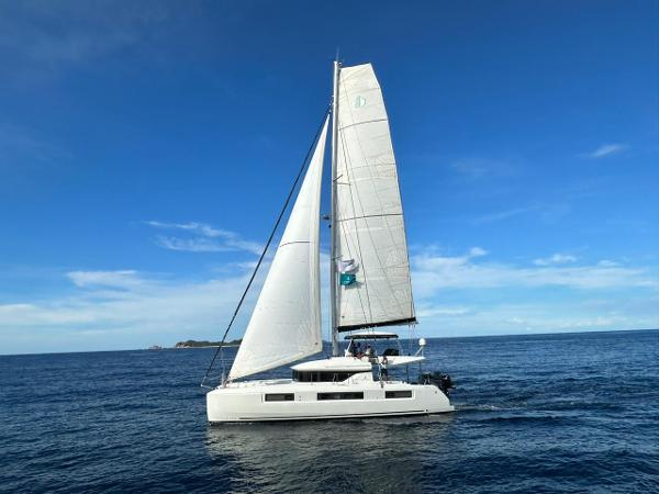 Lagoon 50 2019 Lagoon 50 catamaran sailing on open sea under clear blue sky.