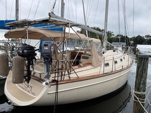 Island Packet 380 2001 Island Packet 380 sailboat docked, featuring dual outboard motors and beige canopy.