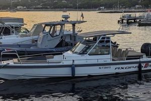 Axopar 28 TTop 2016 Axopar 28 TTop boat docked at sunset, with scenic waterfront background.