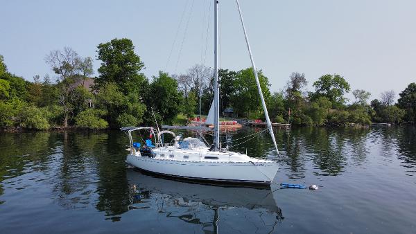 Dufour 39 CC Sailboat Dufour 39 CC 1999 on calm water near lush greenery.