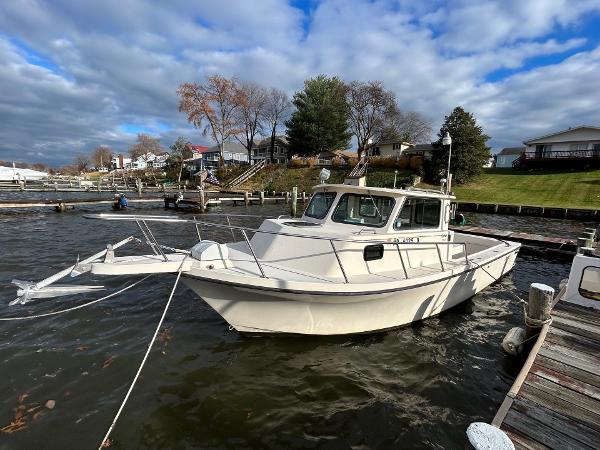 Parker 2520 Sport Cabin 1994 Parker 2520 Sport Cabin boat docked on a scenic waterfront.