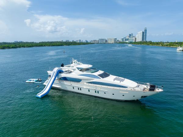 Azimut 116 Luxury Azimut 116 yacht with slide, 2012 model, cruising in scenic waters near city skyline.