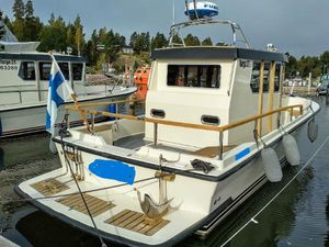 Targa 27.1 2017 Targa 27.1 boat docked, displaying Finnish flag, in a marina setting.