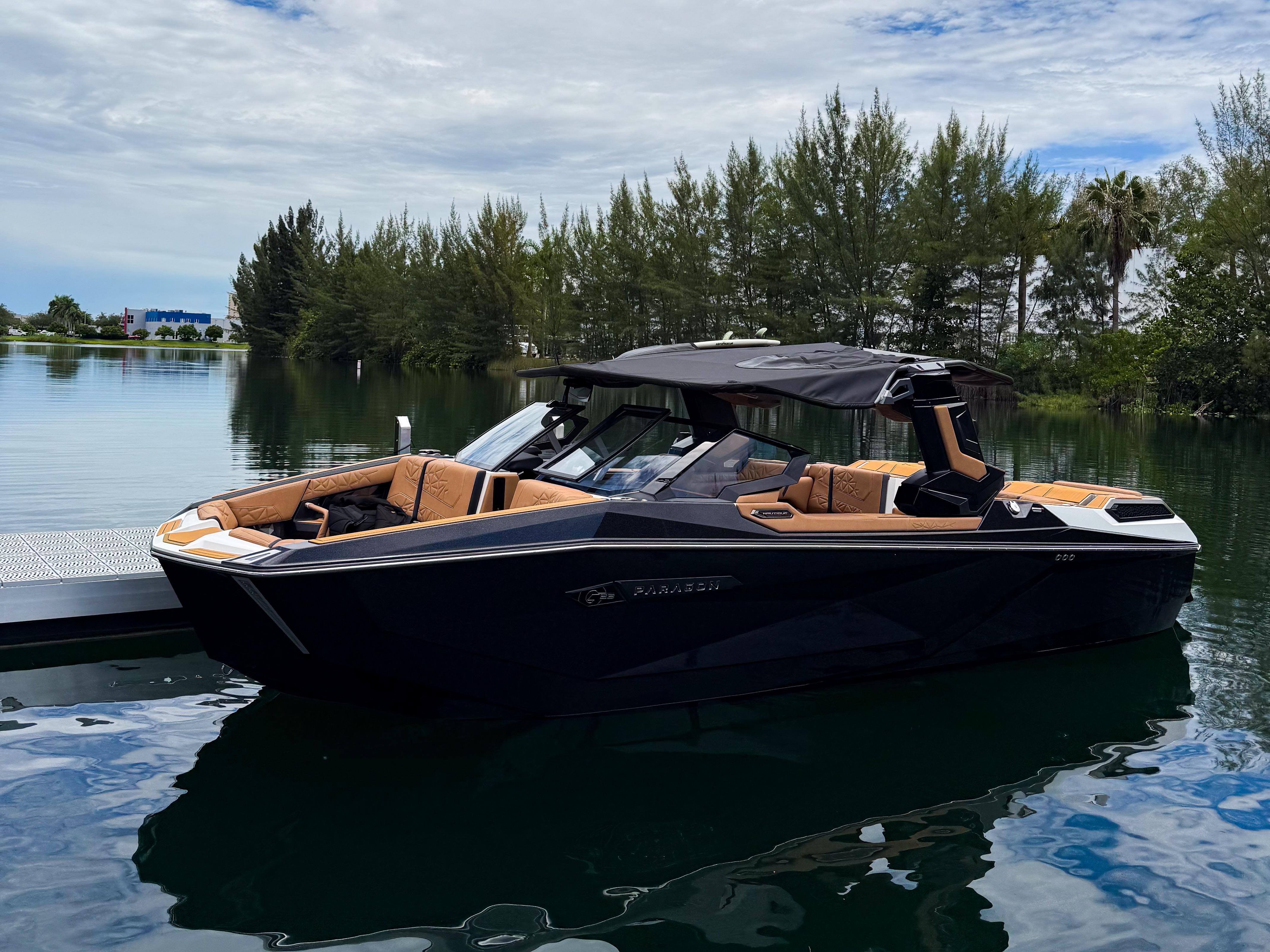 Nautique Paragon G23 2026 Nautique Paragon G23 luxury boat docked on a serene lake.