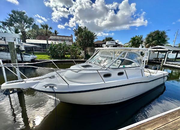 Boston Whaler 305 Conquest 2005 Boston Whaler 305 Conquest boat docked under a bright blue sky.