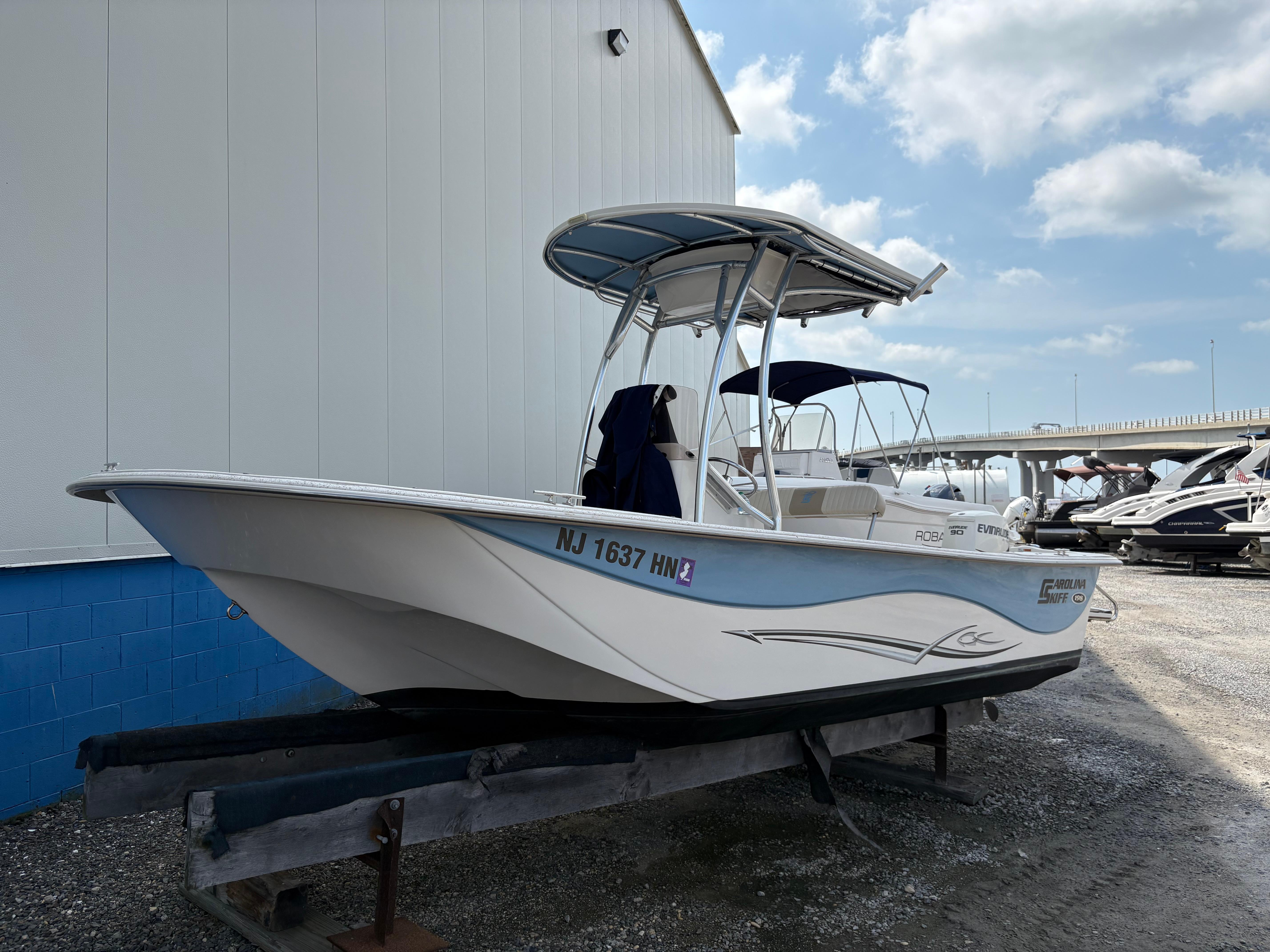 Carolina Skiff 198 DLV 2019 Carolina Skiff 198 DLV boat on trailer, parked outdoors near a building.