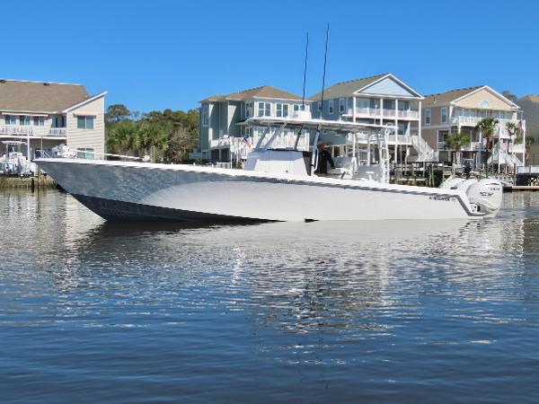 Contender 39 ST 2024 Contender 39ST boat on calm water near waterfront homes.