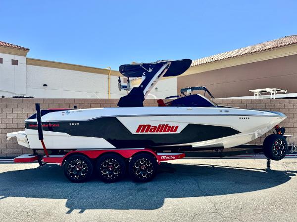 Malibu Wakesetter 25 LSV 2021 Malibu Wakesetter 25 LSV boat on trailer, side view, outdoors.