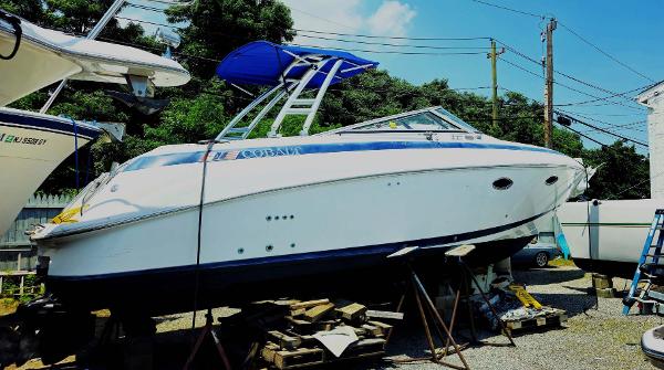 Cobalt 293 1999 Cobalt 293 boat on stands, blue canopy, outdoor storage.