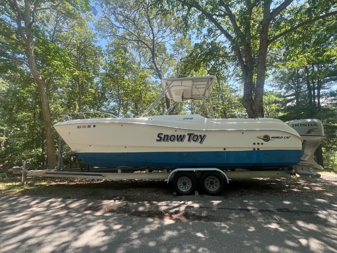 World Cat 266 SD 2007 World Cat 266 SD boat named "Snow Toy" on trailer, surrounded by trees.