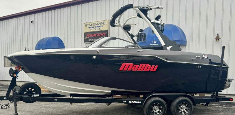 Malibu M220 2024 Malibu M220 boat on trailer at dealership.