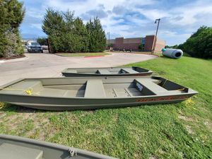 Tracker Grizzly 1436 Utility 2025 Tracker Grizzly 1436 Utility boats on grass near a building.