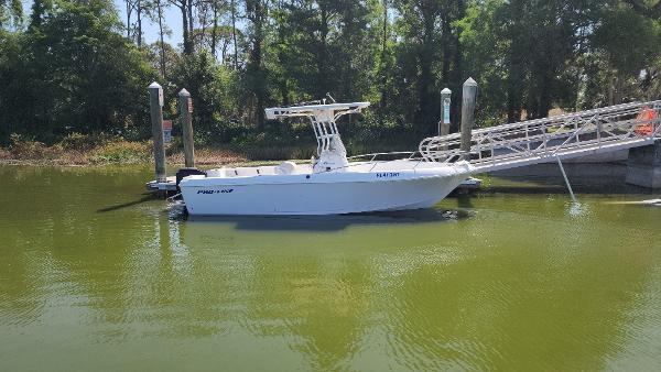 Pro-Line 22 Pro-line 2003 Pro-Line 22 boat docked on calm water near a ramp and trees.