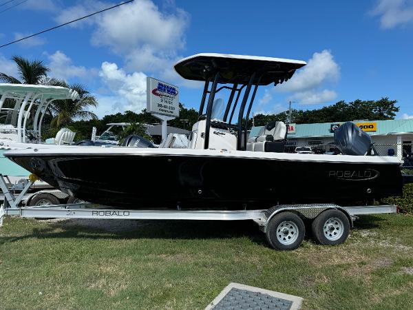 Robalo 226 Cayman 2024 Robalo 226 Cayman boat on trailer, displayed outdoors under blue sky.