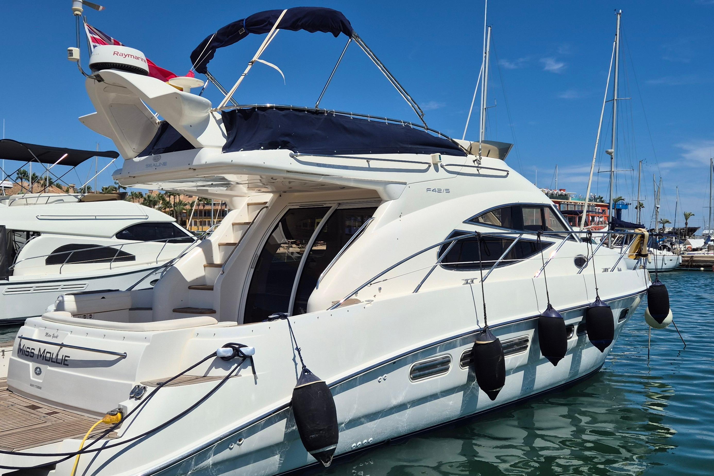 Sealine F42/5 2004 Sealine F42/5 yacht docked in marina, featuring sleek design and modern amenities.