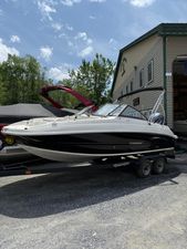 Stingray 201DC 2024 Stingray 201DC boat on trailer, parked outdoors near a building.