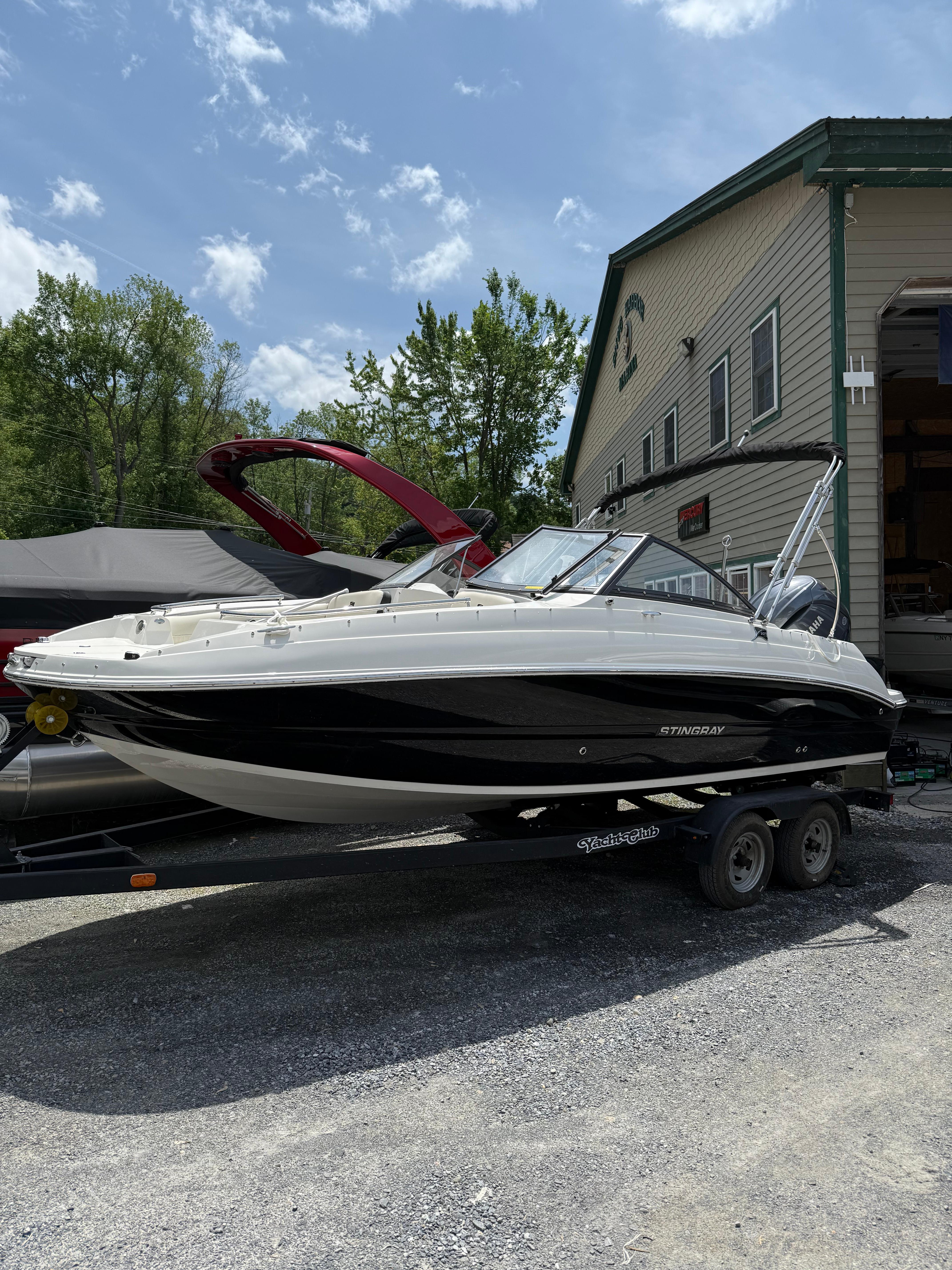 Stingray 201DC 2024 Stingray 201DC boat on trailer, parked outdoors near a building.