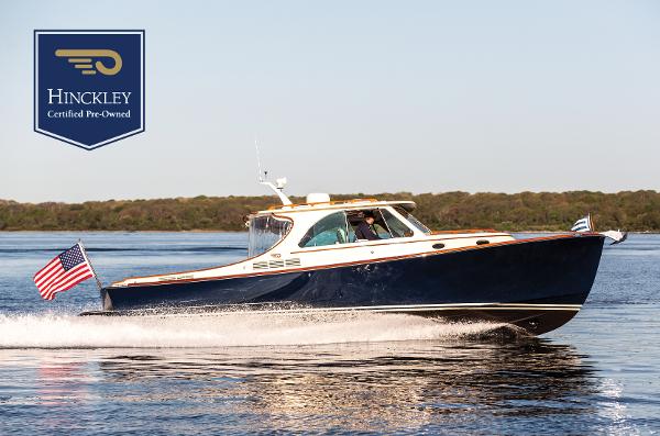 Hinckley Picnic Boat 34 S 2022 Hinckley Picnic Boat 34 S cruising on water, certified pre-owned, with American flag.