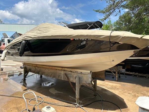 Chaparral 216 SSi 2011 Chaparral 216 SSi boat covered and elevated on a stand outdoors.