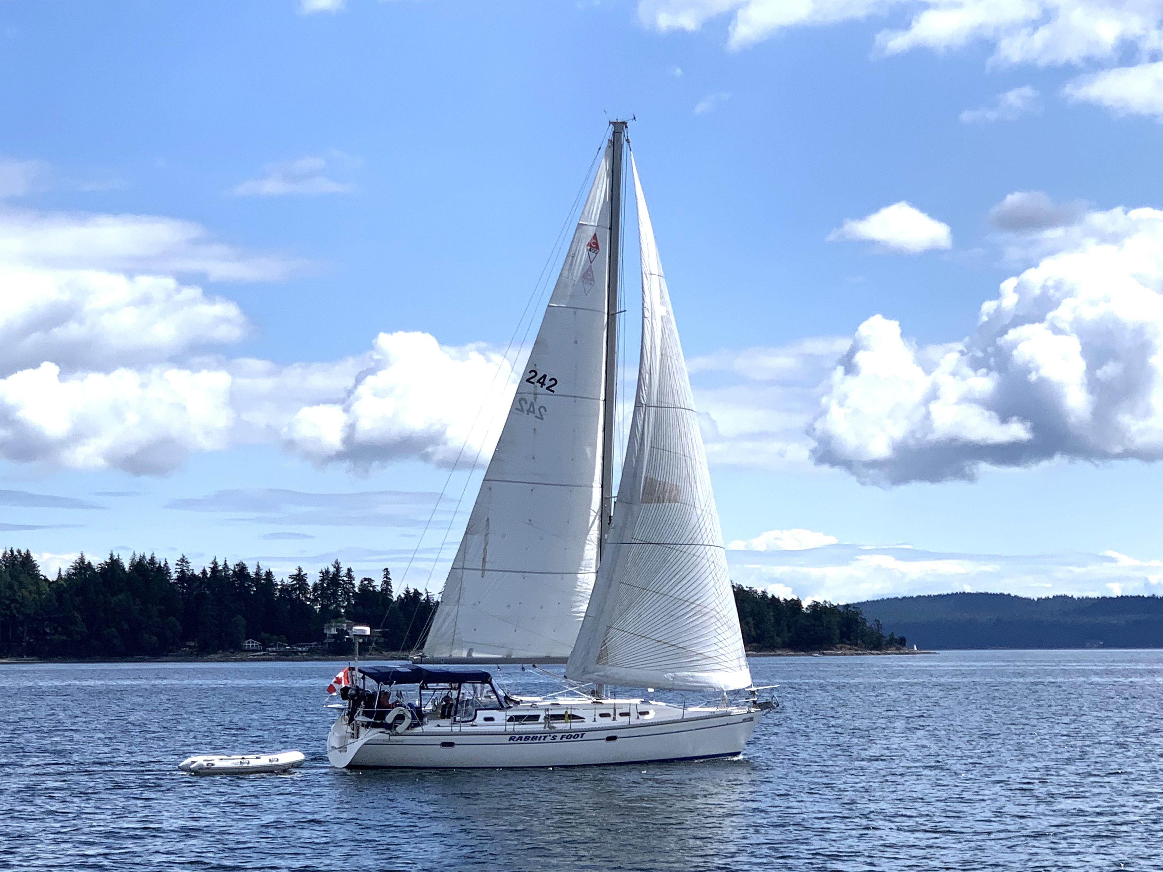 Catalina 400 MkII 2002 Catalina 400 MkII sailboat cruising on a serene lake under a partly cloudy sky.