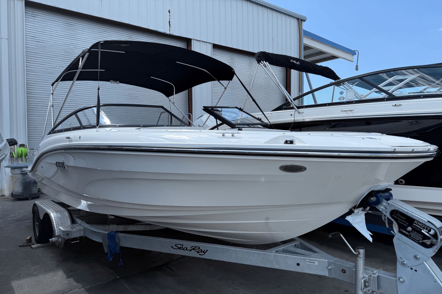 Sea Ray SPX 190 Outboard 2025 Sea Ray SPX 190 Outboard boat on trailer, featuring sleek design and black canopy.