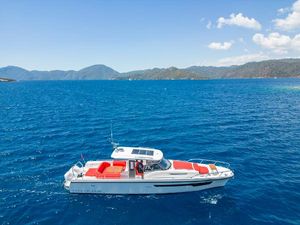Nimbus T11 2023 Nimbus T11 boat cruising on clear blue sea with scenic mountain backdrop.