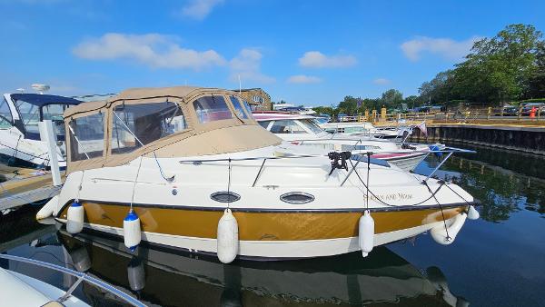 Stingray 240CS 1999 Stingray 240CS boat docked at marina under clear blue sky.