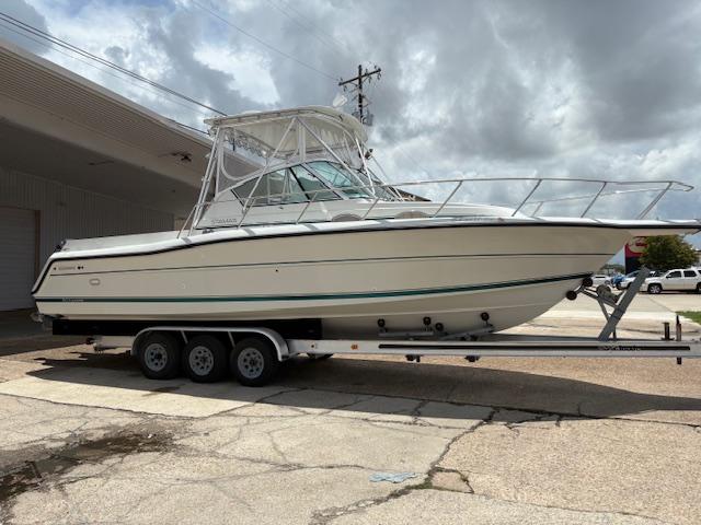 Stamas 310 Express 1997 Stamas 310 Express boat on a trailer, parked outdoors under cloudy skies.