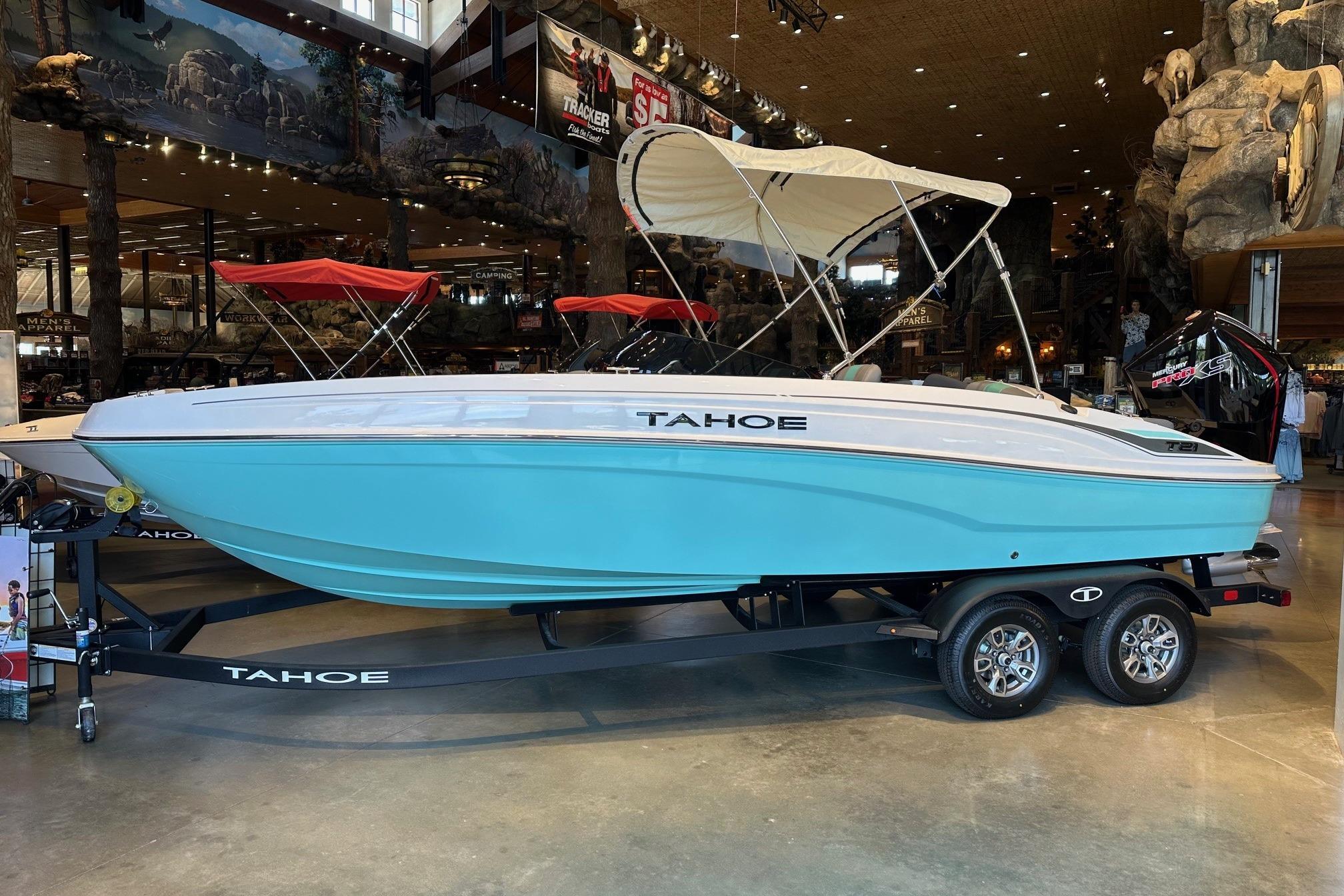 Tahoe T21 2026 Tahoe T21 boat in showroom, light blue hull, canopy, on trailer.