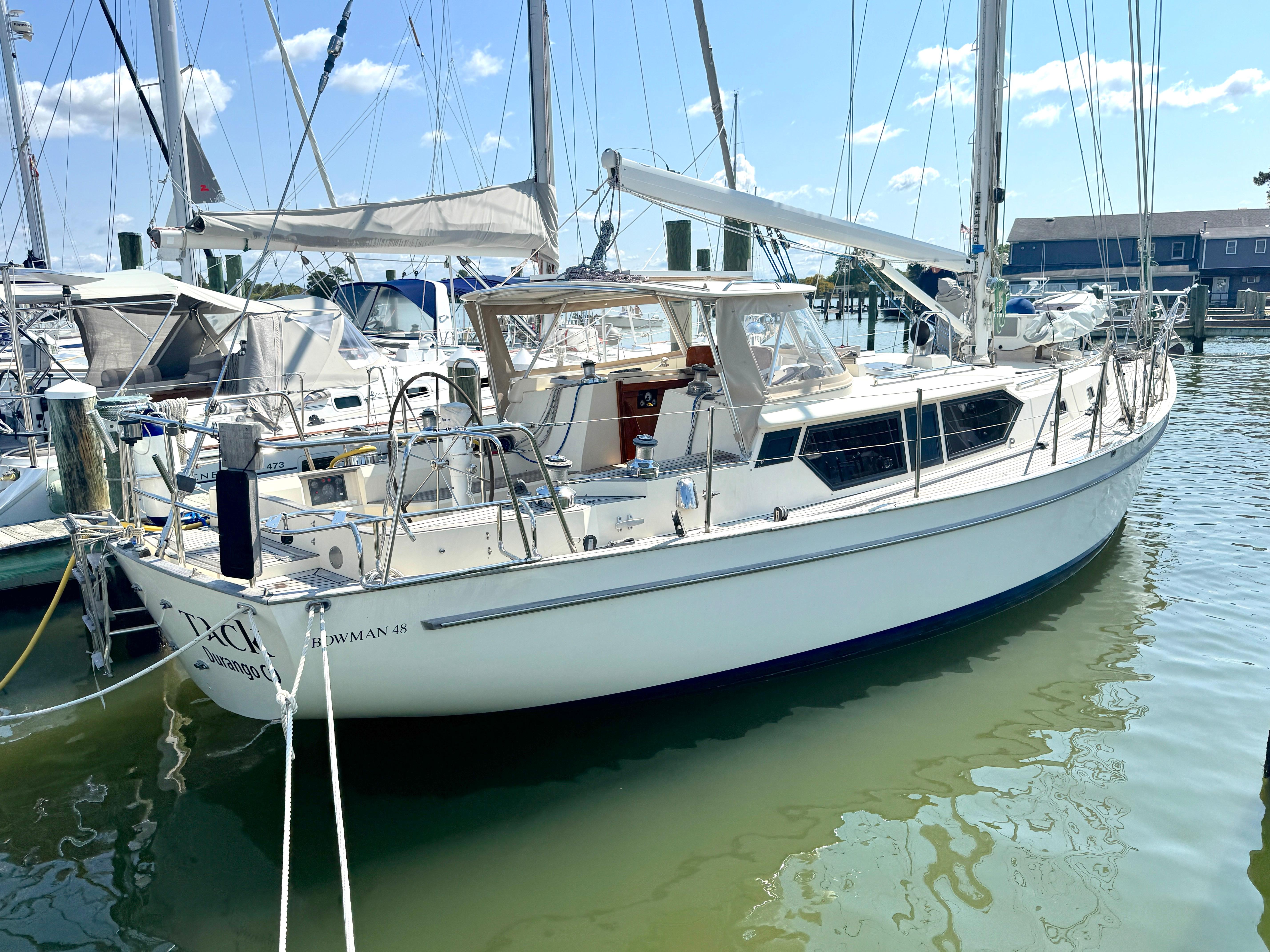 Bowman 48 Aft Cockpit 1999 Bowman 48 Aft Cockpit sailboat docked in a marina under clear skies.
