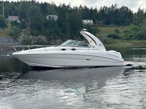 Sea Ray 300 Sundancer 2004 Sea Ray 300 Sundancer cruising on a calm lake with forested shoreline.