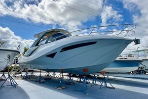 NX Boats 360 Sport Coupe 2024 NX 360 Sport Coupe boat displayed on stands under a cloudy sky.