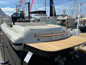 Scanner Envy 1100 Luxury yacht with wooden deck displayed at a boat show, surrounded by other vessels.