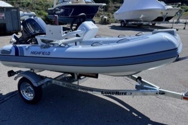 Highfield Classic 310 FCT 2024 Highfield Classic 310 FCT inflatable boat on LoadRite trailer in marina setting.