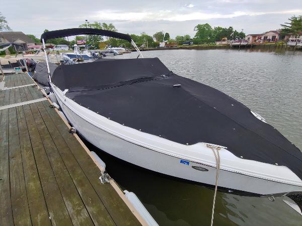 Cobalt R5 2016 Cobalt R5 boat docked with black cover on a calm lake.