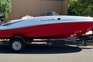 Tahoe T16 2026 Tahoe T16 boat in red and white on a trailer, parked outdoors.