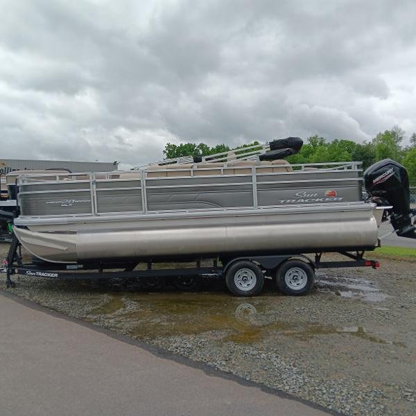 Sun Tracker Fishin' Barge 20 DLX 2025 Sun Tracker Fishin' Barge 20 DLX pontoon boat on trailer, overcast sky.