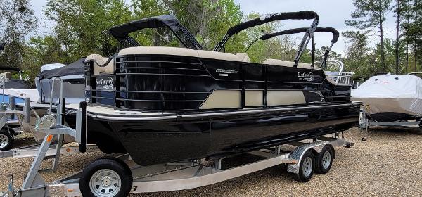 SunCatcher Elite 324 SS 2023 SunCatcher Elite 324 SS pontoon boat on a trailer in a boatyard.