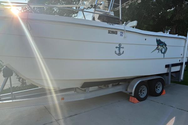 Pro Sports 2200 CC ProKat 2003 Pro Sports 2200 CC ProKat boat on trailer, sunlight reflecting, anchor and fish decals visible.