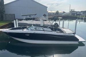 Four Winns H260 2014 Four Winns H260 boat docked in a marina, side view.