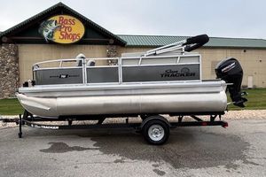 Sun Tracker Bass Buggy 16 XL Select 2026 Sun Tracker Bass Buggy 16 XL Select pontoon boat on trailer outside Bass Pro Shops.
