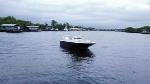 Boston Whaler 210 Montauk 2022 Boston Whaler 210 Montauk boat on a calm river with overcast skies.