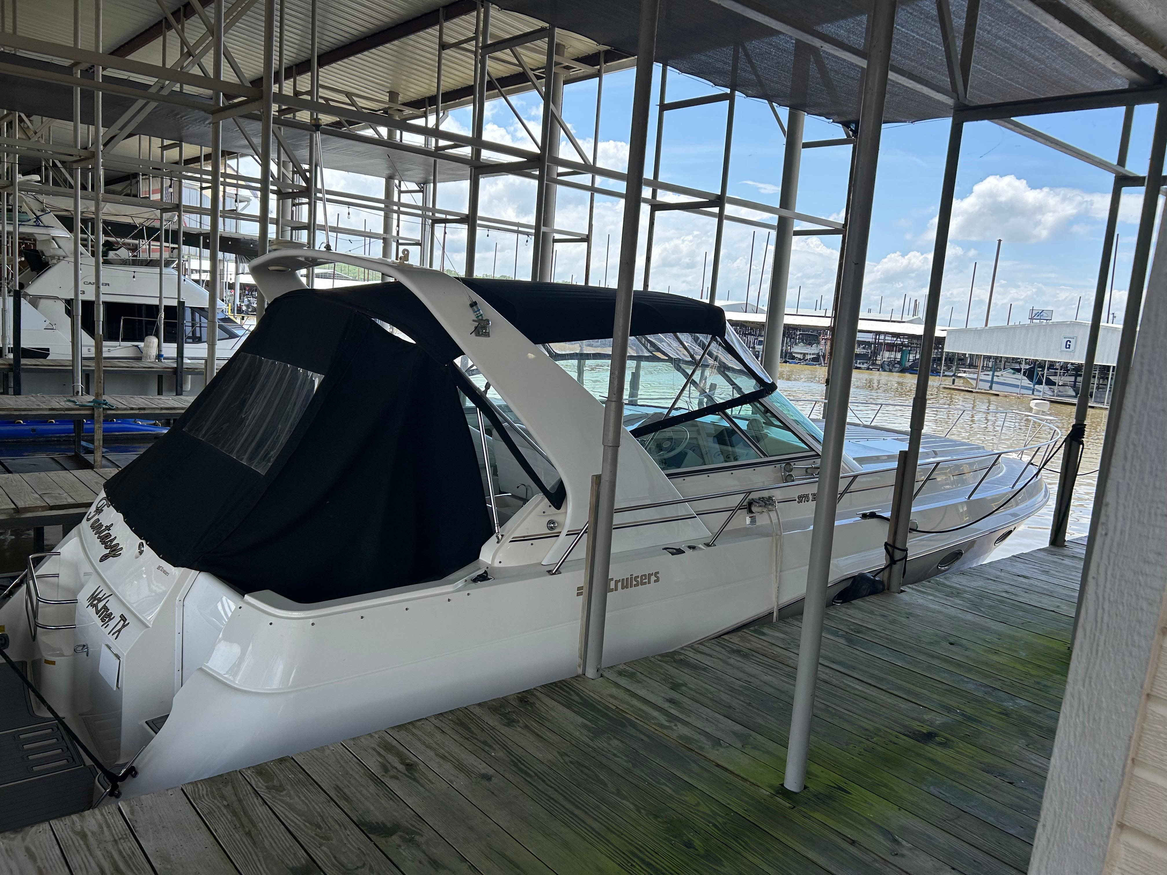 Cruisers Yachts 3775 Esprit 1997 Cruisers Yachts 3575 Esprit docked under a covered marina with clear skies.