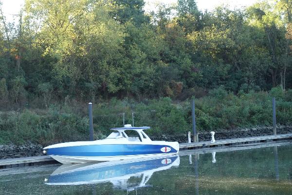 Cigarette 42 Huntress 2014 Cigarette 42 Huntress boat docked by a forested shoreline.