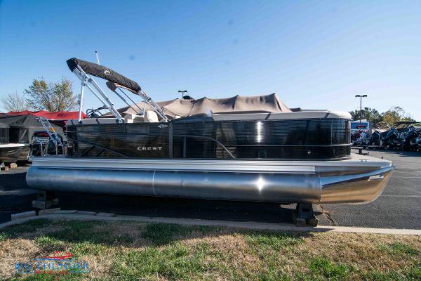 Crest Classic DLX 240 SLC 2024 Crest Classic DLX 240 SLC pontoon boat in a parking lot.
