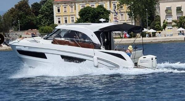 Beneteau Antares 9 OB 2020 Beneteau Antares 9 OB cruising on water near coastal buildings.